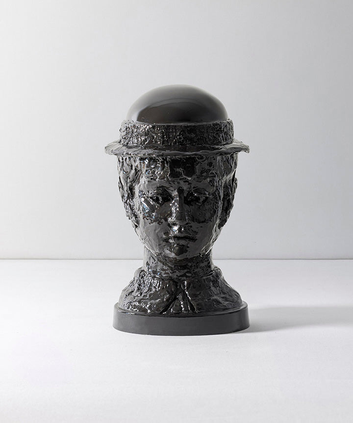 BRUTALIST BEAUTY | Black bust sculpture of a person wearing a bowler hat on a white background