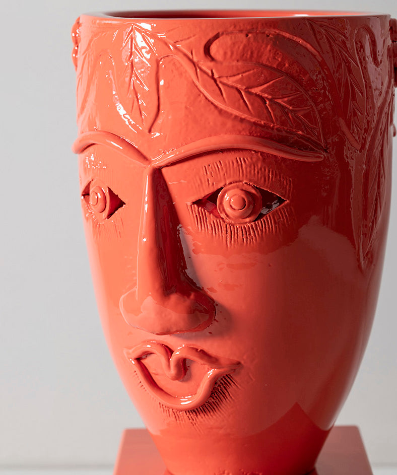 Double faced terracotta vessel sitting on solid marble base.