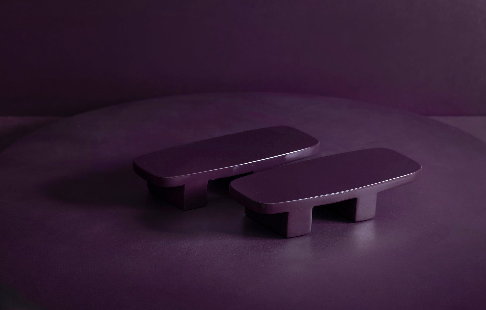 Two purple rectangular objects on a dark purple background