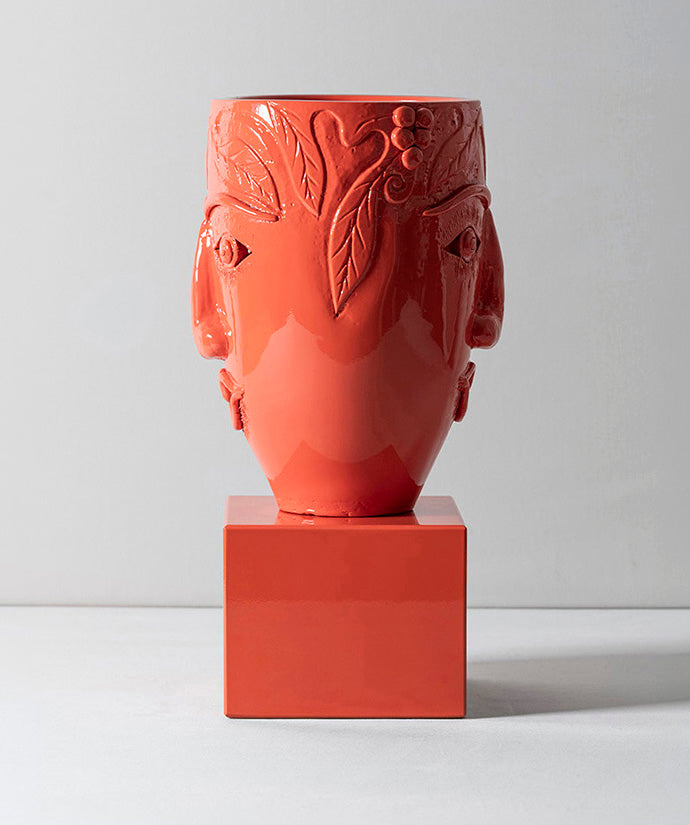 Double faced terracotta vessel sitting on solid marble base. 